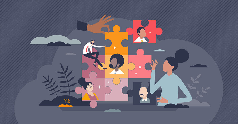 Diverse team members fit together puzzle pieces, symbolizing collaboration and teamwork.